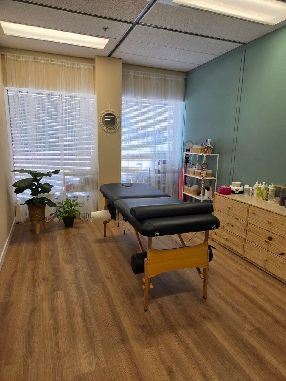 Oh, Honey studio treatment room with massage table, plants, and natural light